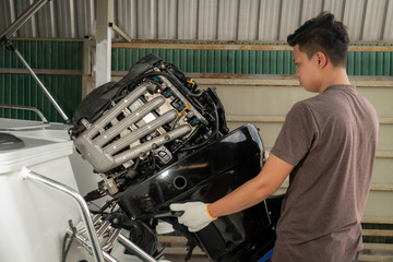 Repairing engines on aluminum boats , The technician is removing the boat parts to make the paint