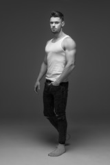 young man with a beard. A man in a t-shirt. Male portrait on a gray background. Stylish man. black and white photo. Sports man. male fitness model. studio portrait