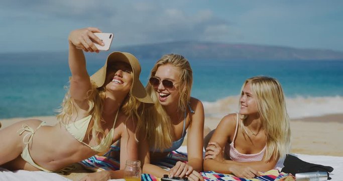 Friends taking selfies together on the beach