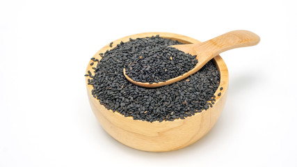 Black sesame seeds in a spoon and bowl on a white background.