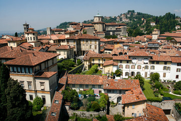 Fototapeta na wymiar Bergamo, view over the red tile roofs and towers of medieval historical Old Town, Lombardy, Italy. May 2012