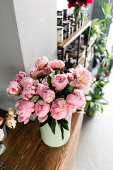 The counter of the flower shop. Pink peonies in a metal vase. Beautiful peony flower for catalog or online store. Floral shop concept . Beautiful fresh cut bouquet. Flowers delivery
