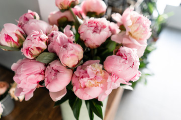 The counter of the flower shop. Pink peonies in a metal vase. Beautiful peony flower for catalog or online store. Floral shop concept . Beautiful fresh cut bouquet. Flowers delivery
