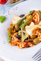 colorful farfalle with green asparagus olives and parma ham