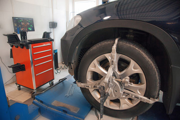 car repair: wheel replacement closeup. mechanic screwing or unscrewing car wheel at car service garage