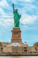 Fototapeta premium Statue of Liberty on Liberty Island, New York City. Cloudy Blue Sky Background, Vertical Banner