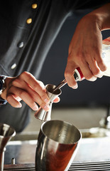 Making cocktail, pouring liquor in jigger 