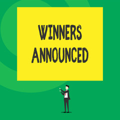 Word writing text Winners Announced. Business concept for Announcing who won the contest or any competition Isolated view young man standing pointing upwards two hands big rectangle.