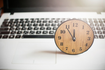 Fototapeta na wymiar concept Laptop and clock tell time 12 pm