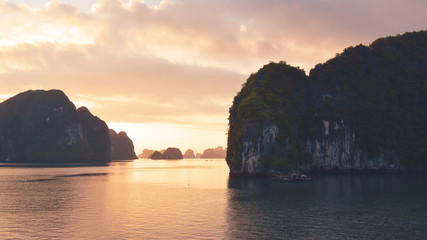 Halong bay at golden sunrise in Vietnam, South Asia. Panoramic view. Travel destination and natural...
