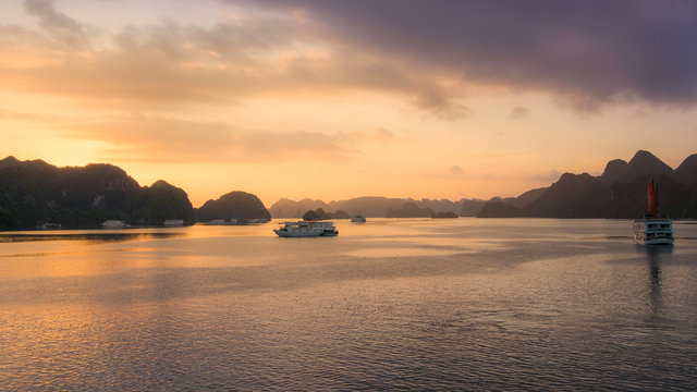 Halong bay at sunrise in Vietnam, South Asia, and Tourist Junks. Panoramic view. Travel destination and natural background.