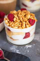 Fresh yoghurt with rasberries and coffee in clear glass. Raspberries in white bowl. Healthy morning breakfast.