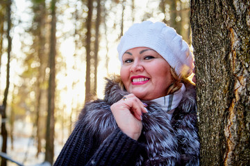 Portrait of beautiful plump woman in a nice winter forest