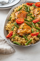 Grilled chicken thighs with bulgur, asparagus beans and tomatoes. Delicious lunch.