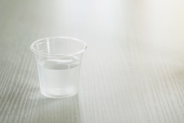 Drinking water in a clear glass on a white table