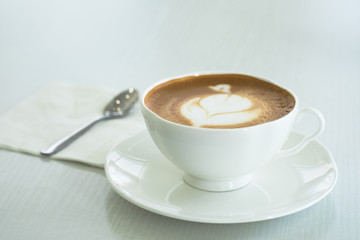 Cappuccino in a white cup on a white table