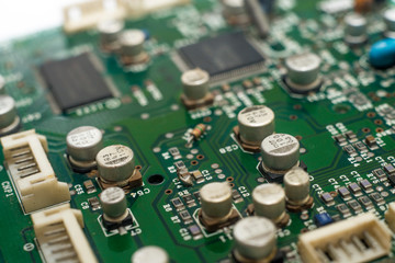 close-up circuit board with electronic components on green printed