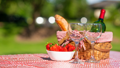 picnic basket checkered with a tablecloth wine, baguette, strawberry, glasses, banner