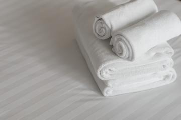 white fluffy towels on bed in hotel bedroom. Close up view