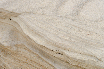 Layers of sand on the beach, soft sandstone at the shore. Abstract background texture