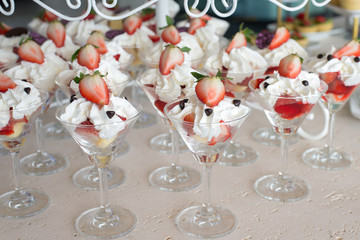 Strawberries with whipped cream glass in a row