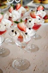 Strawberries with whipped cream glass in a row