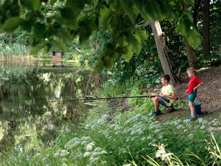 Naklejka na ściany i meble teen child catches a fishing rod on the pond.