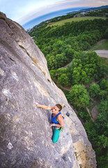 Naklejka premium Woman climbs rock.