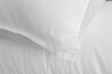 White soft pillow and bedsheet top view. White beddings.