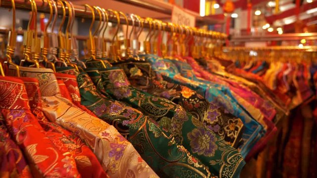 4K Traditional Chinese dress hanging on rack in shopping mall, Zoom out shot