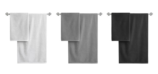 White, black and grey cotton terry towels hanging on a rail isolated