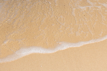 Close up of soft wave of ocean on the sand, background.