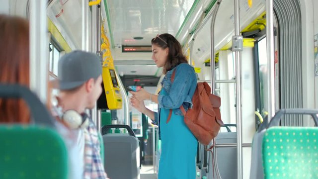 Woman paying conctactless with smartphone for the public transport in the tram