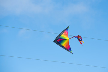 Colorful kite stuck in the electric power lines.