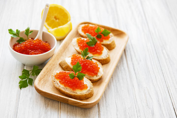 Red caviar in bowl and sandwiches