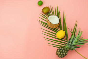 Table top view fruit tropical with spring summer holiday & vacation  background concept.Arrangement sliced various pineapple mango lemon and lime on palm green leaves.Items on pink paper.pastel tone.