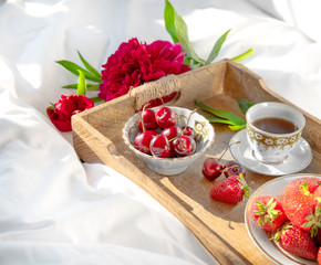 Tray with delicious breakfast on bed