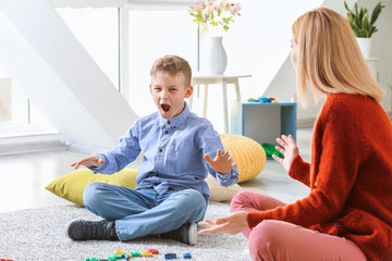 Female psychologist working with boy suffering from autistic disorder