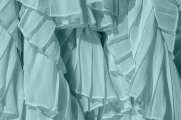 Powdered pastel mint color chiffon fabric folds.Turquoise dress with ruffles and frills. 