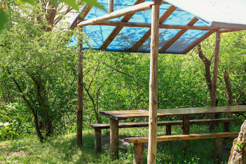 Fototapeta premium Wooden arbor in forest on sunny day