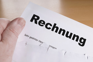 Rechnung hand holding german invoice letter with opened envelope