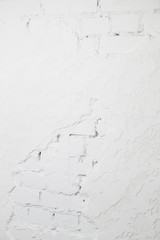 Texture of an old white concrete wall with small holes and a shadow