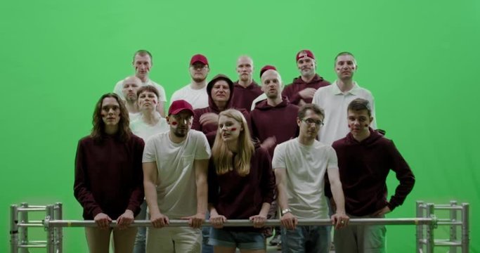 GREEN SCREEN CHROMA KEY Front view group of people fans wearing red clothes watching a sport event. 4K UHD ProRes 422 HQ
