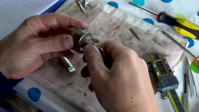 Top view locksmith turning key in disassembled lock cylinder