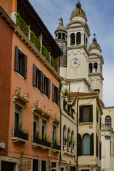 Architecture and landmark of Venice. Cozy cityscape of Venice. Venetian street with bell towers and a clock tower.