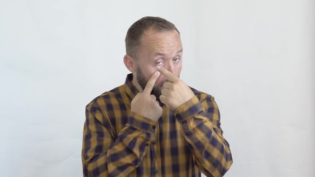 concept of emotions and feelings that we experience when dealing with people. close-up of an attractive bearded man in a plaid shirt on a white background showing
