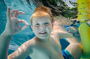 Junger Pooltaucher zeigt mit Fingern OK