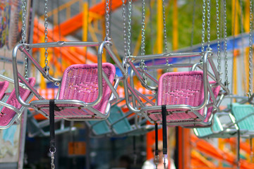 Empty pink chair of chair swing ride at amusement park