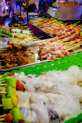 Various types of meat such as squid, pork, chicken, beef and vegetables are skewed for roasting. Placed for customers to choose to buy Is a street food that can be seen in Thailand (Spot focus)