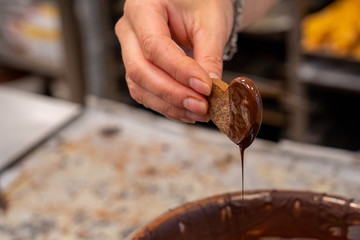 Detail of tea paste, the confectioner is decorating chocolate tea pastes, heart shape